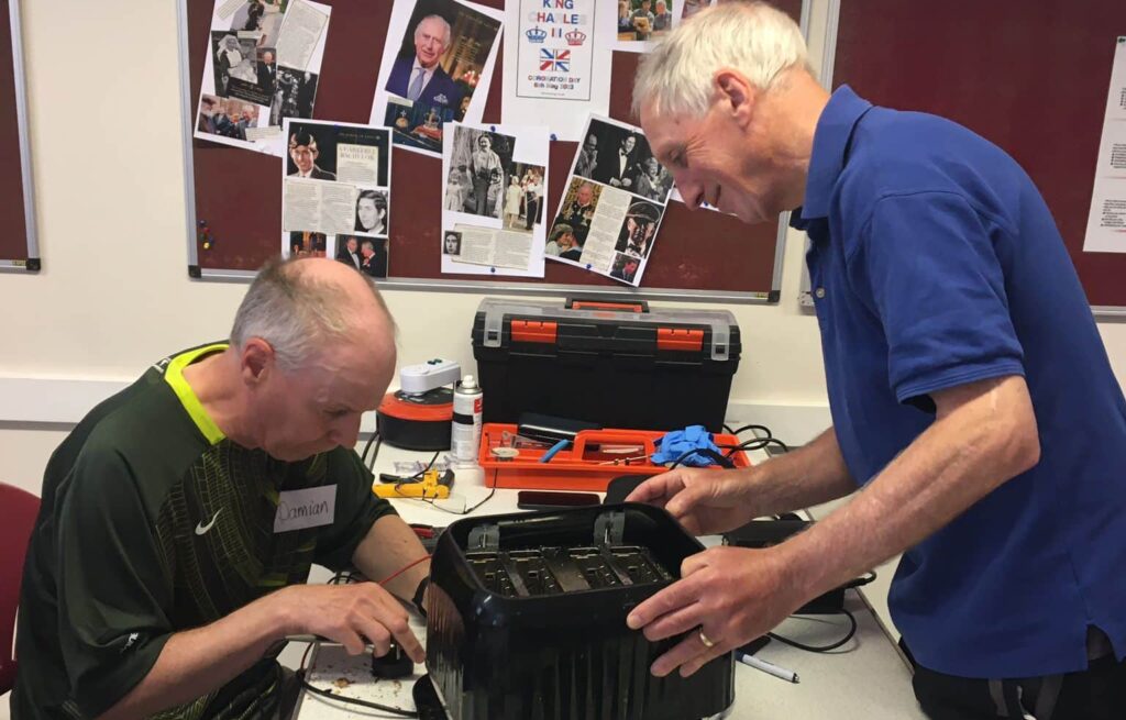 two men repairing electrical equipment